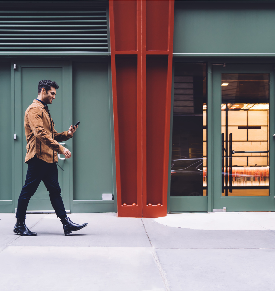 Man walking in the street looking at his his mobile phone